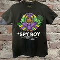 Black mardi gras t-shirt with 'Spy Boy' graphic design on a brick wall background