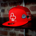Red cap with embroidered loyalty club logo and spy boy space broccoli pins